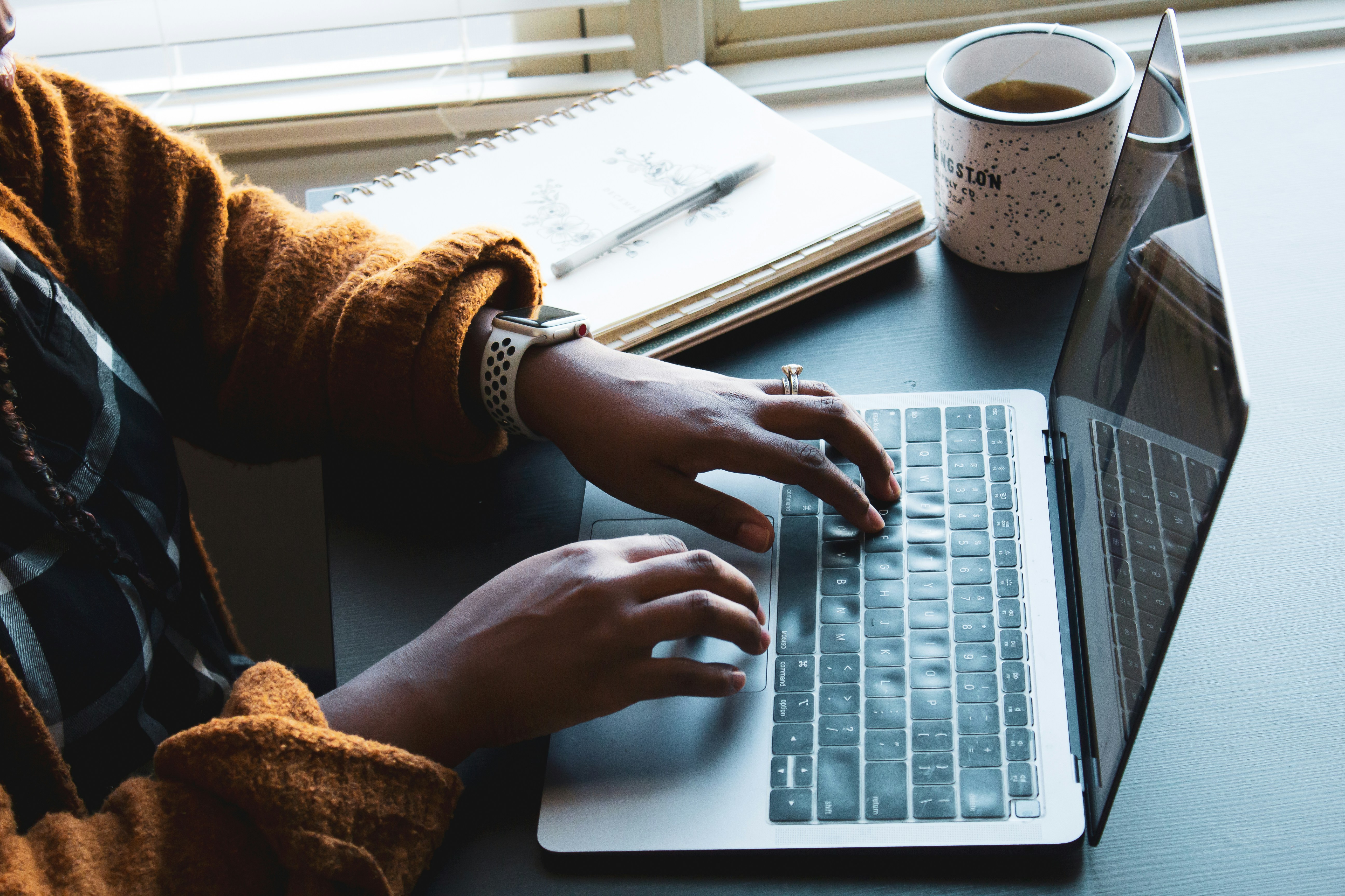 zoom in on hands typing on a laptop