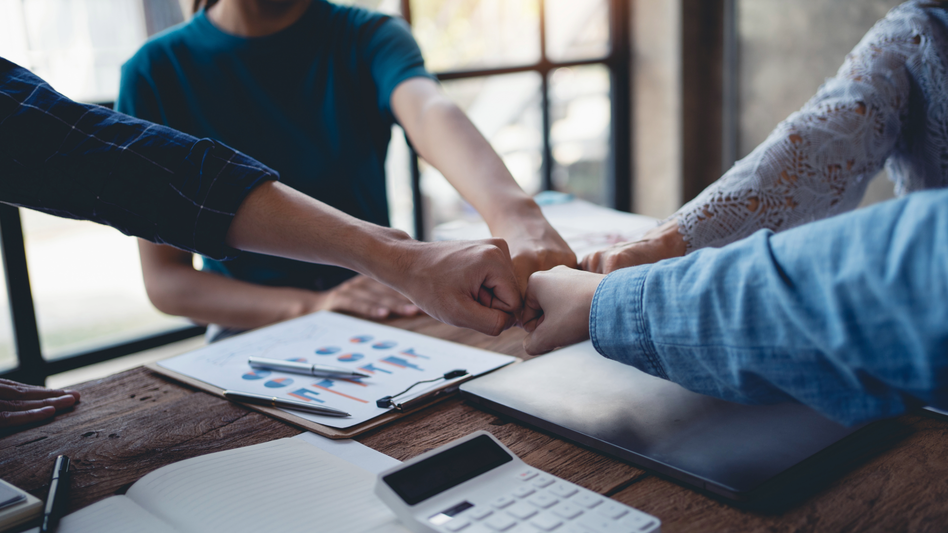 Young entrepreneurs work as a team meeting and work together on a new project that emphasizes unity and fist-pumping teamwork as a promise of unity in the workplace.