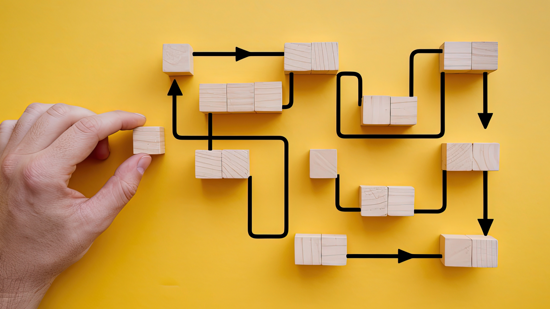 Image of a hand placing blocks in a maze-like pattern
