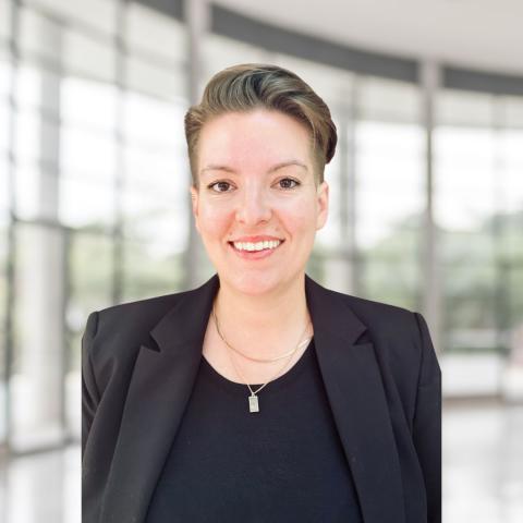 woman with short brown hair wearing black blazer and black shirt