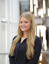 Woman smiling with long blond hair in a black blazer